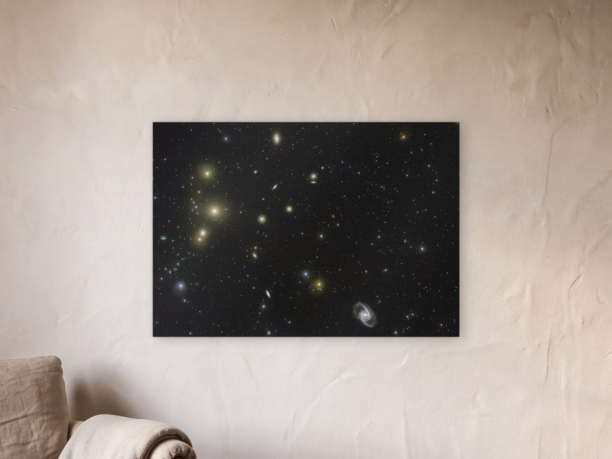 Fornax galaxy cluster shown in a limewash reading corner beside an armchair and a floor lamp - scale render at 100 × 70 cm